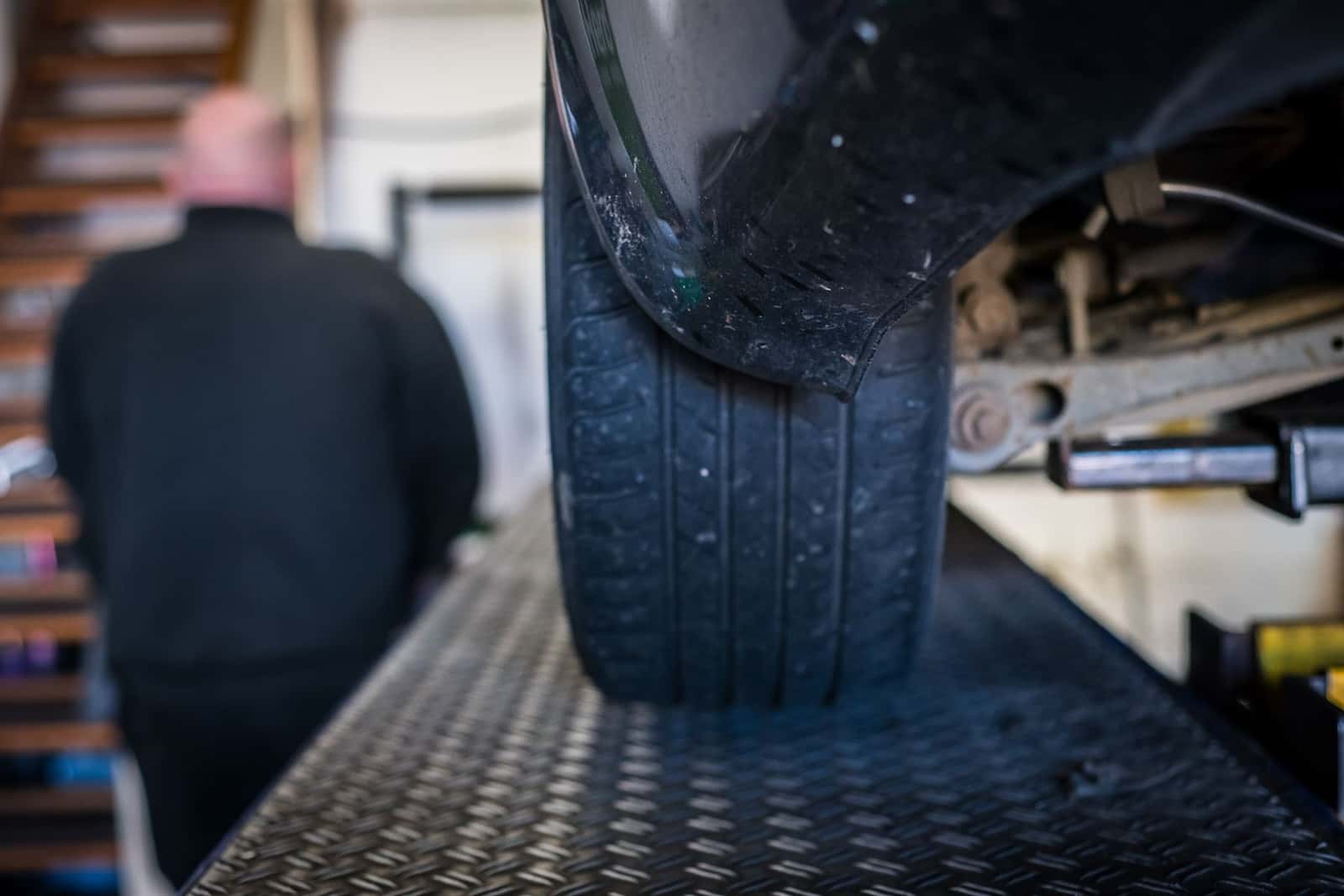 A car tyre being checked on the ramp in the workshop